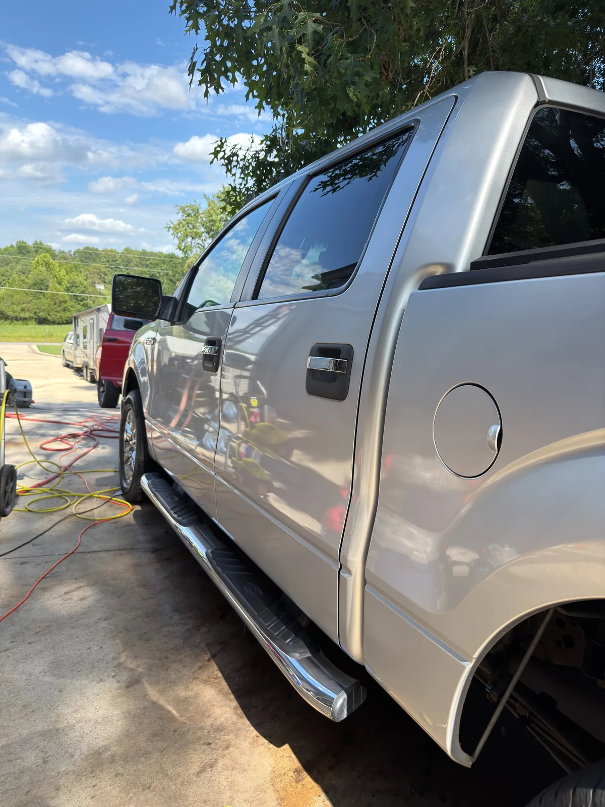 Silver Ford F-150 crew cab cleaned down the side with chrome steps shining